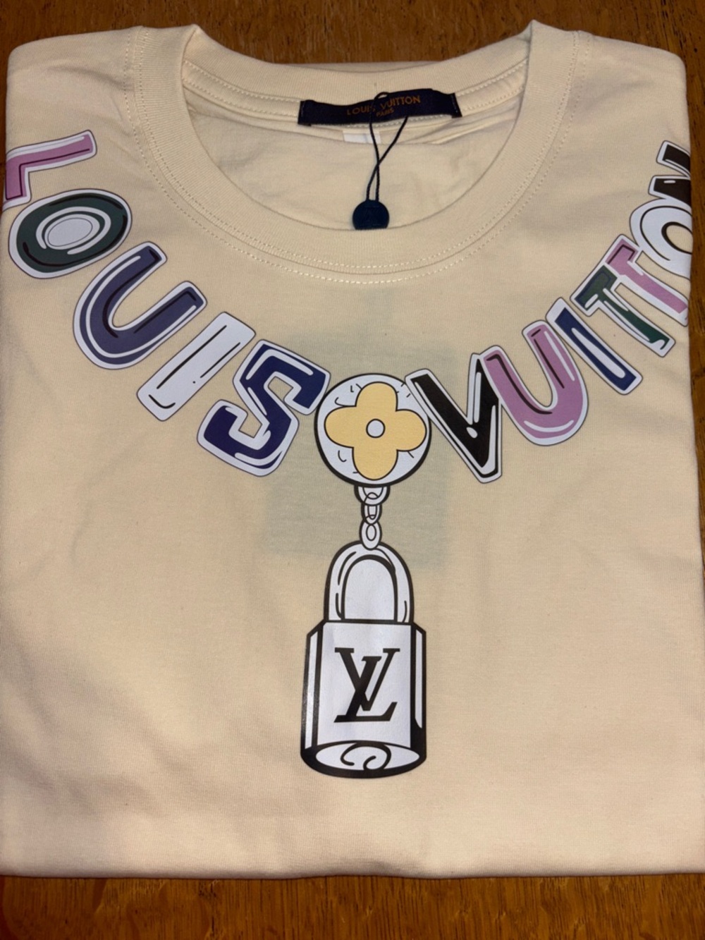 Louis Vuitton Cream Kids Tee with Multicolor Logo and Padlock Graphic read 👇